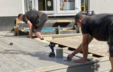 Garden landscaping team installing composite decking. Professional landscaping services by the Essex Garden Co.