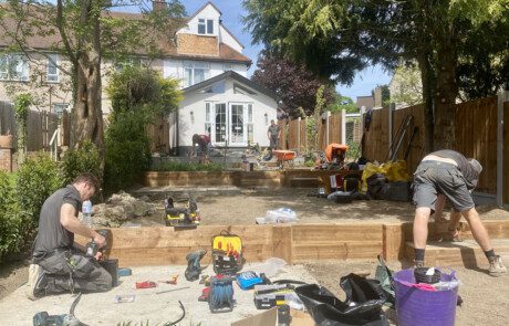 Garden landscaping team of Essex Garden Co, installing wooden sleepers as steps in a large multi-level garden.
