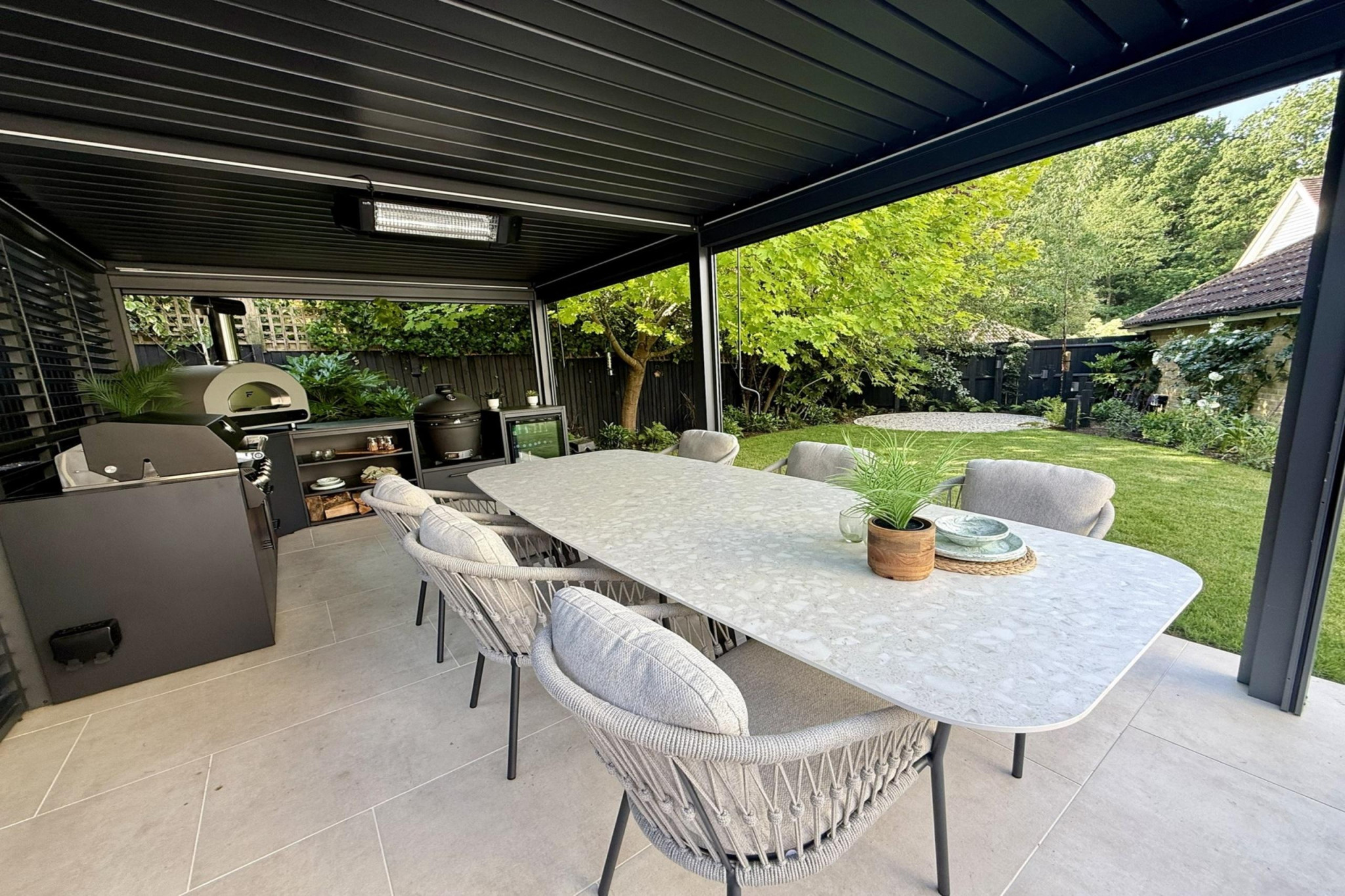 Full garden re-design in Warley, Essex.Low maintenance garden design. Pergola installation and outdoor kitchen with table and chairs for entertainment.