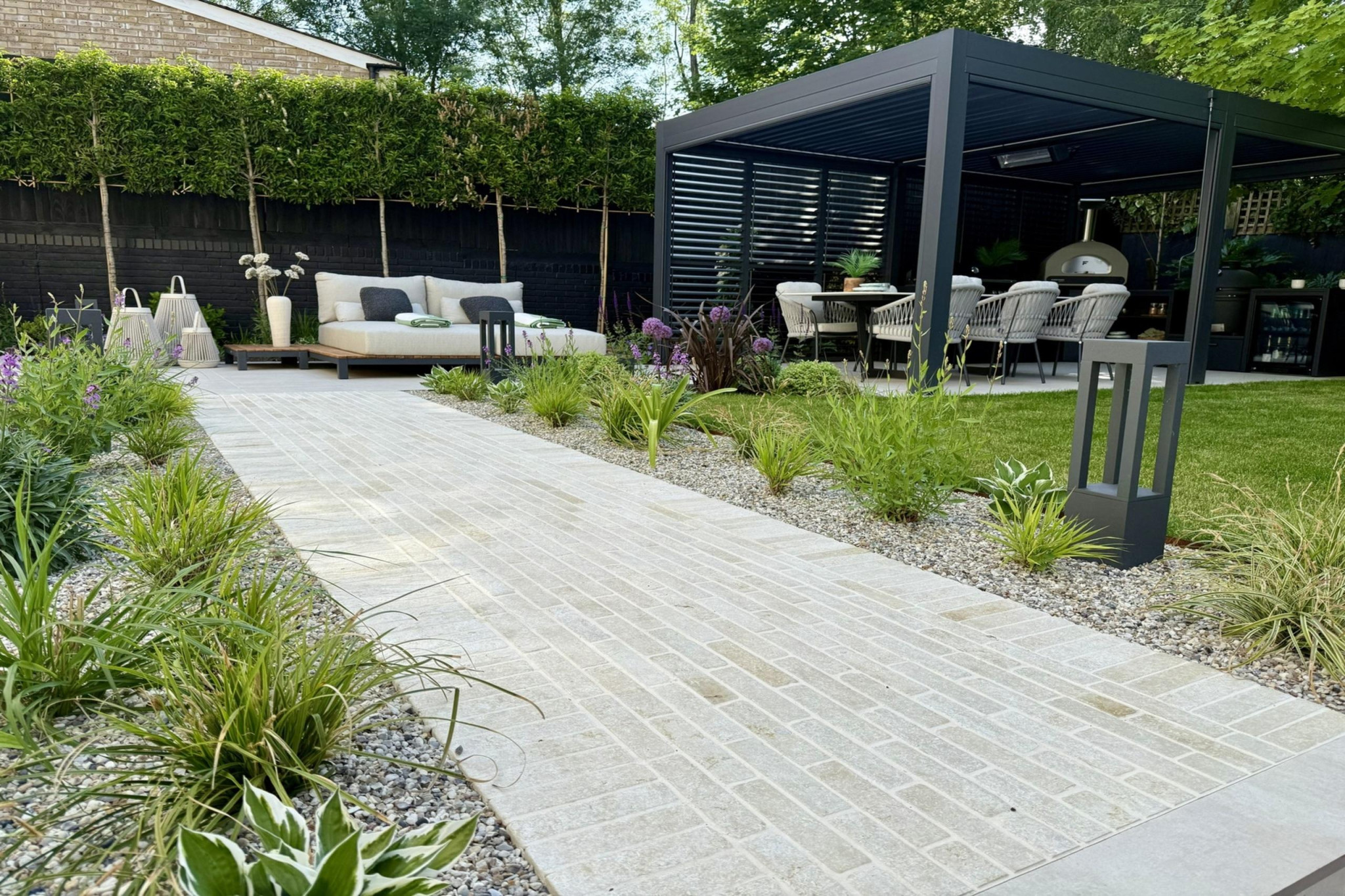 Full garden re-design in Warley, Essex.Low maintenance garden design. Featture paving, near pergola entertainment area with sun loungers and easy to maintain borders.