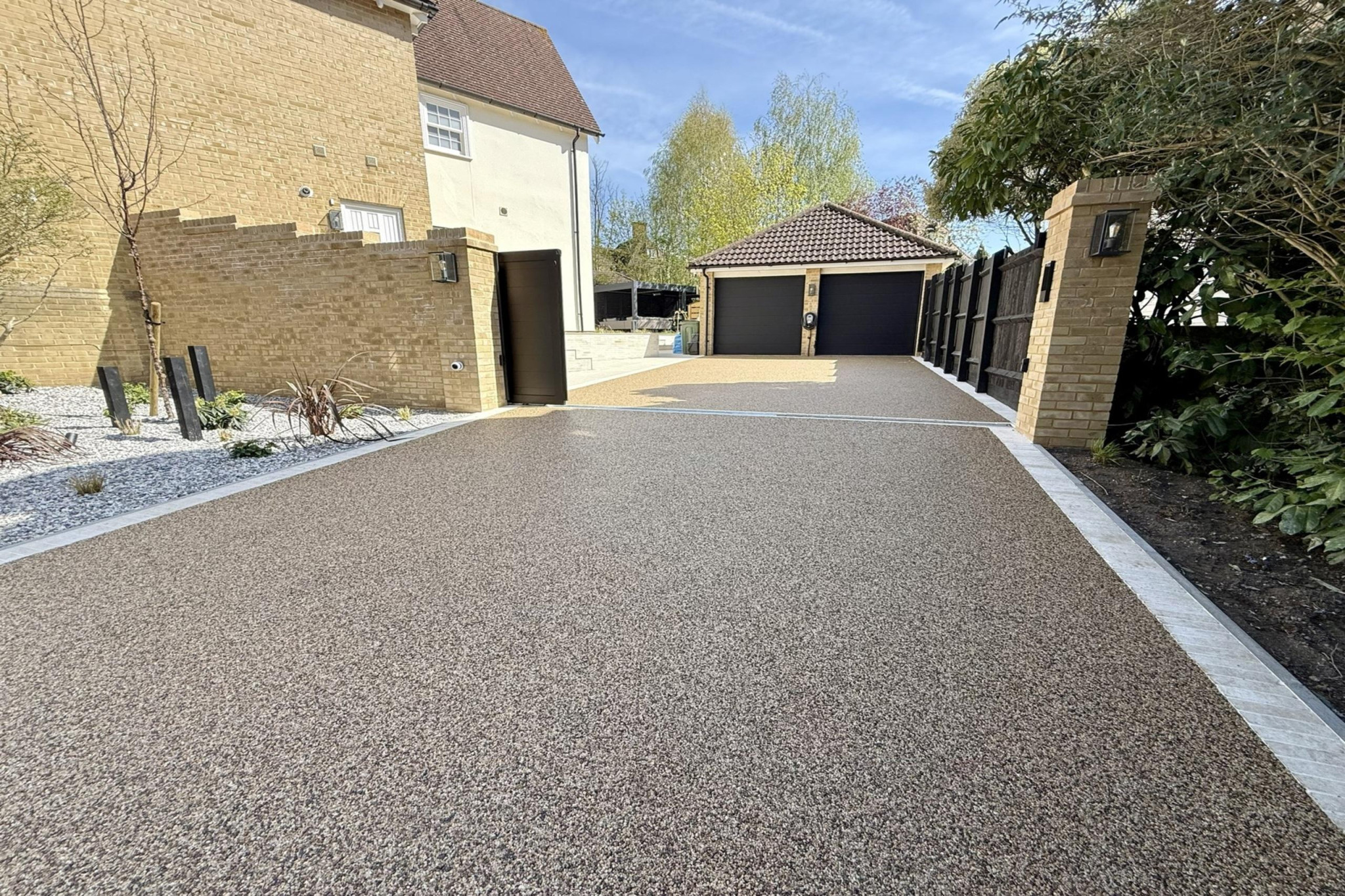 Full garden re-design in Warley, Essex.Low maintenance garden design. Resin driveway leading up to double garage.