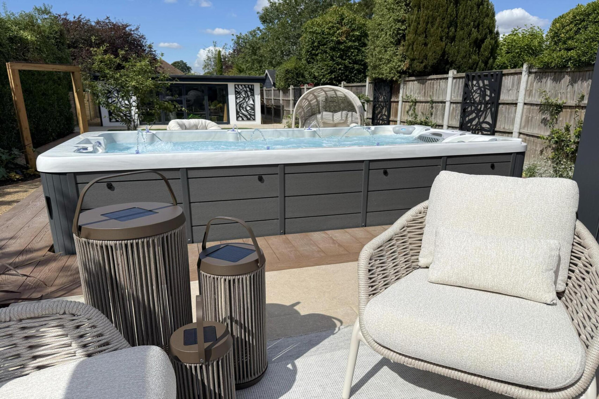 Garden transformation in Corbetts Avenue, Upminster. Essex. Features include: porcelain paving, clay pavers, louvered pergola, outdoor kitchen, swim spa, rain arch, lighting, planting, turf, resin, Irrigation. Garden design and lanscape transformation by The Essex Garden Co.