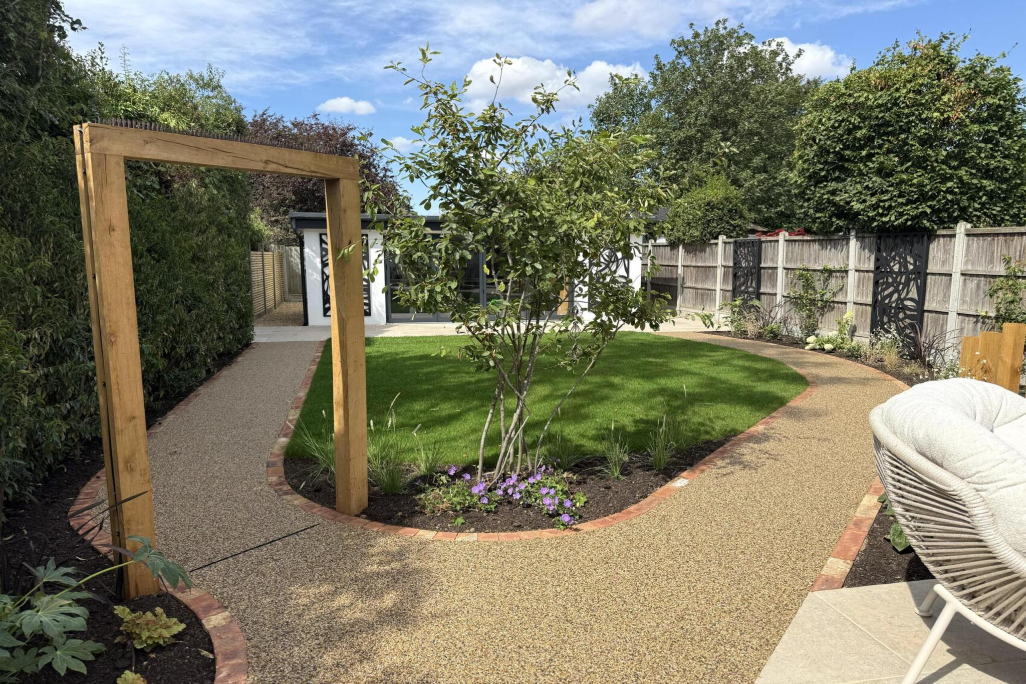 Garden transformation in Corbetts Avenue, Upminster. Essex. Features include: porcelain paving, clay pavers, louvered pergola, outdoor kitchen, swim spa, rain arch, lighting, planting, turf, resin, Irrigation. Garden design and lanscape transformation by The Essex Garden Co.