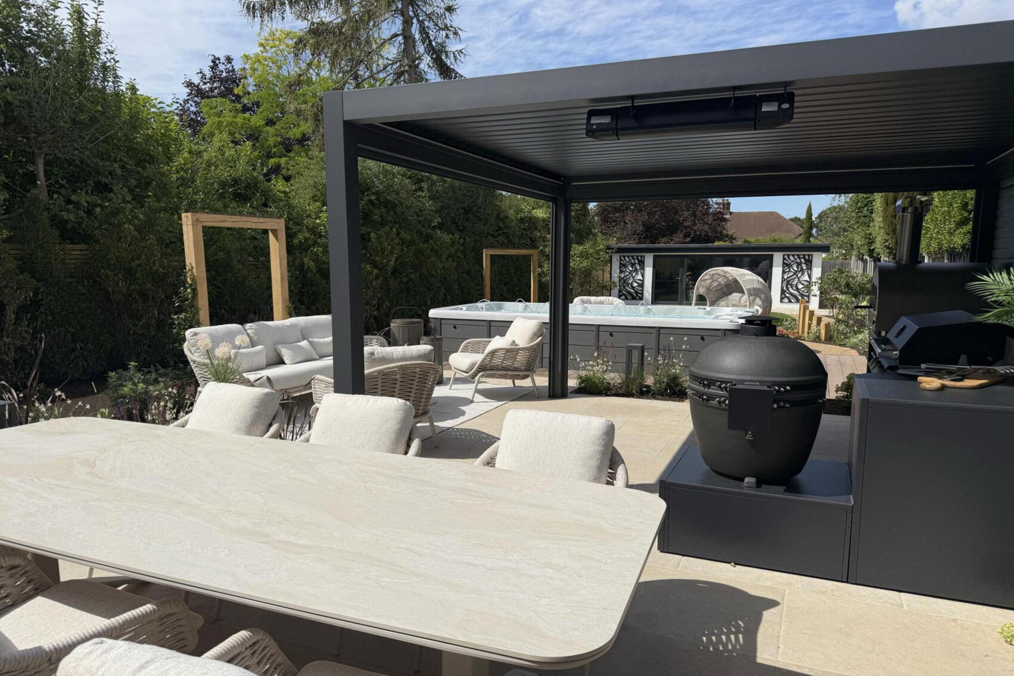 Garden transformation in Corbetts Avenue, Upminster. Essex. Features include: porcelain paving, clay pavers, louvered pergola, outdoor kitchen, swim spa, rain arch, lighting, planting, turf, resin, Irrigation. Garden design and lanscape transformation by The Essex Garden Co.