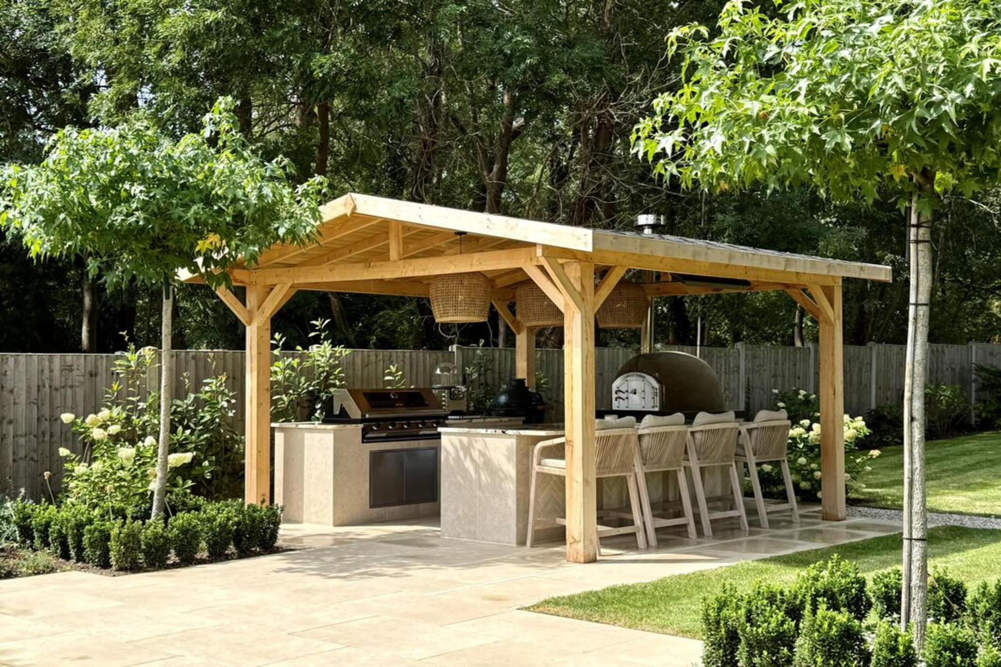 Garden transformation in Hall Lane, Upminster. Essex garden design and landscaping features: porcelain paving, feature pavers, timber gazebo, outdoor kitchen, umbrella trees, lighting, planting, turf, stabilising grids, gravel and irrigation.