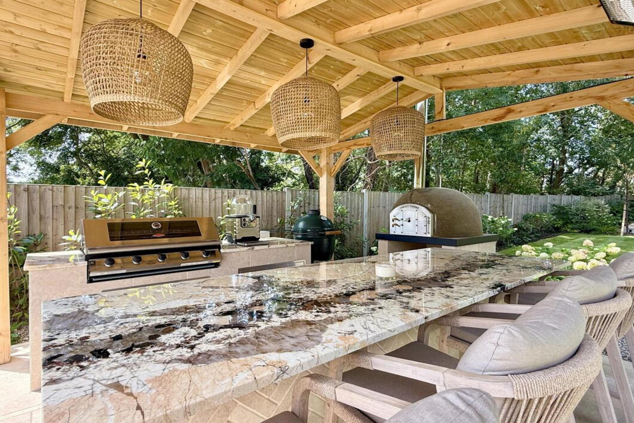 Garden transformation in Hall Lane, Upminster. Essex garden design and landscaping features: porcelain paving, feature pavers, timber gazebo, outdoor kitchen, umbrella trees, lighting, planting, turf, stabilising grids, gravel and irrigation.