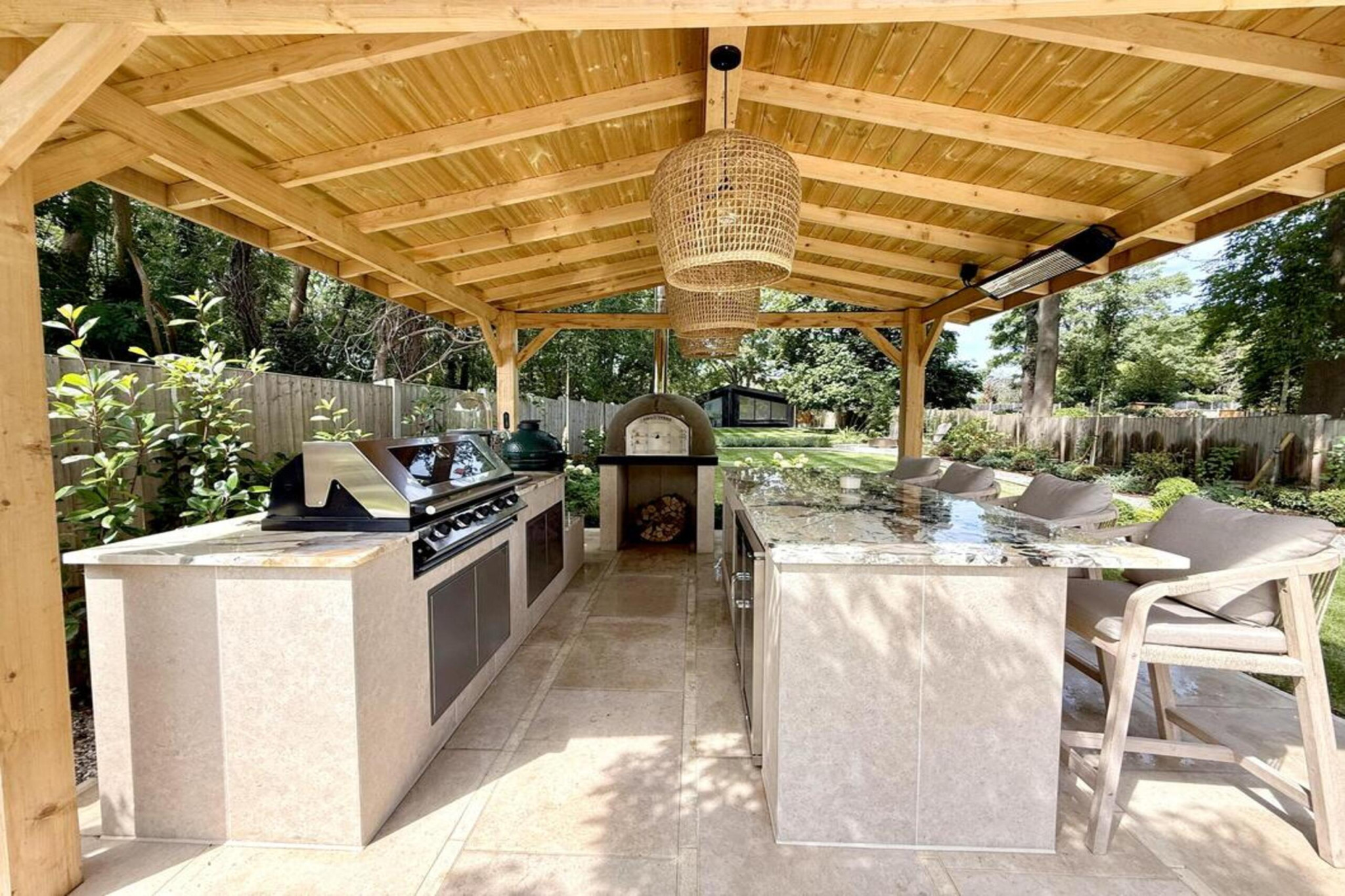 Garden transformation in Hall Lane, Upminster. Essex garden design and landscaping features: porcelain paving, feature pavers, timber gazebo, outdoor kitchen, umbrella trees, lighting, planting, turf, stabilising grids, gravel and irrigation.